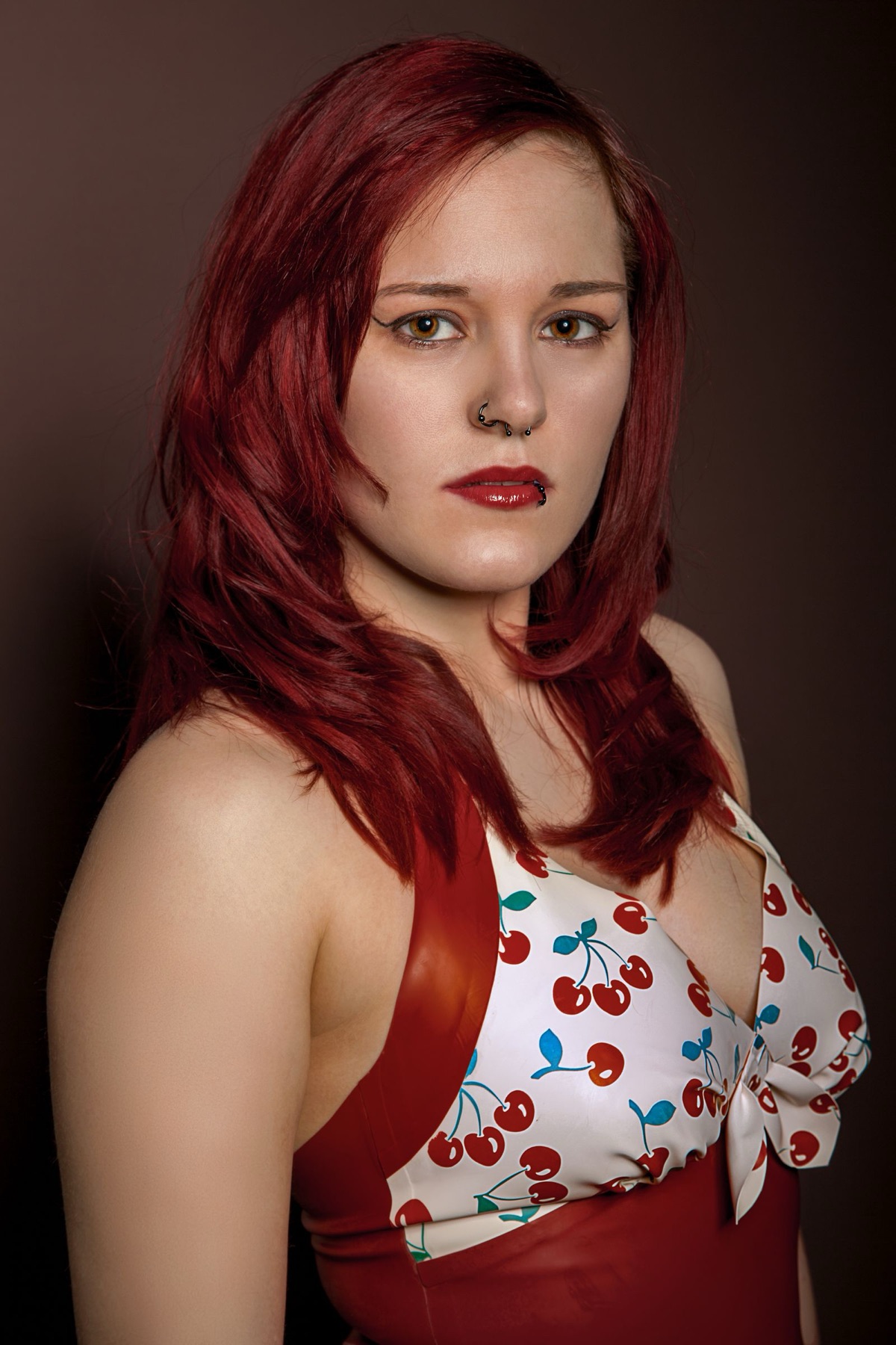 Model in einem rot-weißen Latex-Top mit Kirschmuster